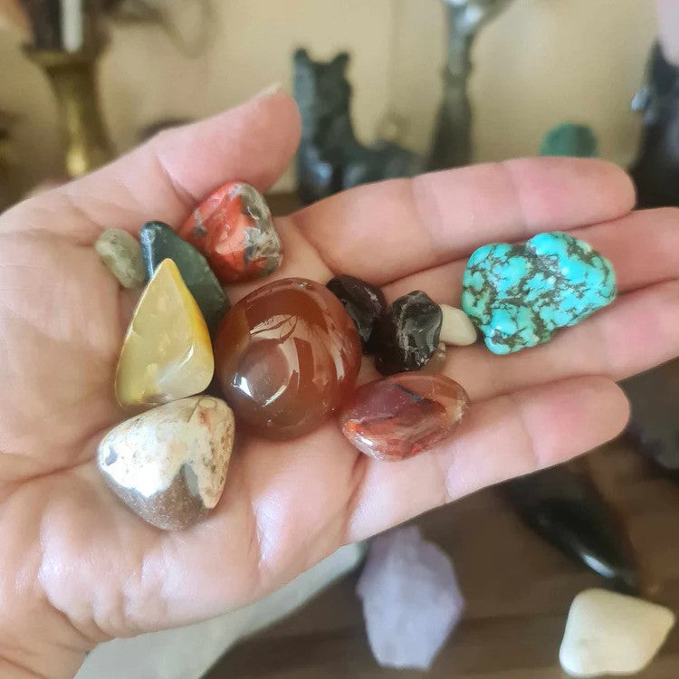 A Selection Of Tumbled Crystals Held In The Palm Of A Hand