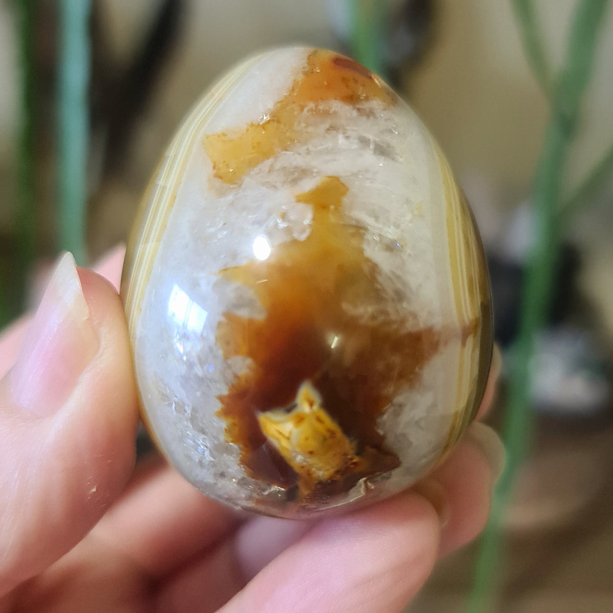 orange and white crystal egg in a hand