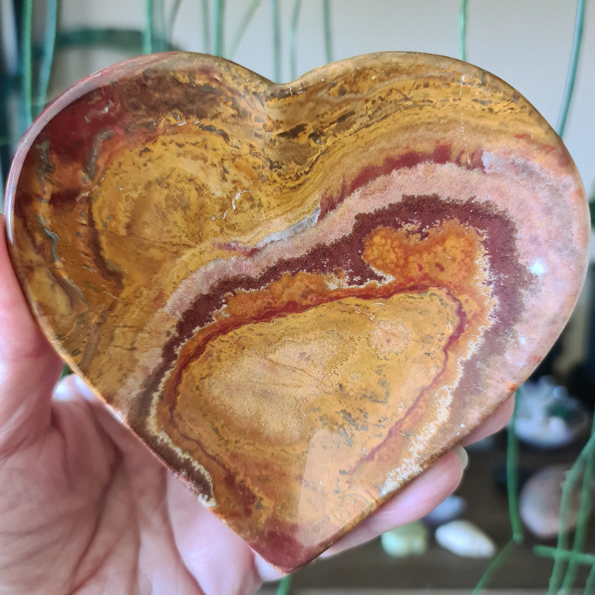 brown and green crystal onyx heart shaped plates held in a hand