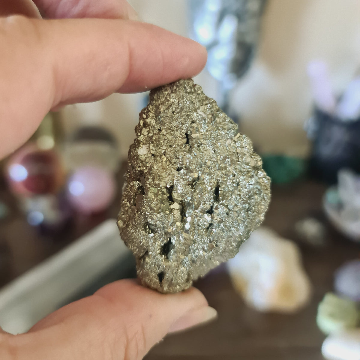 A person holding a large, polished pyrite crystal chunk.