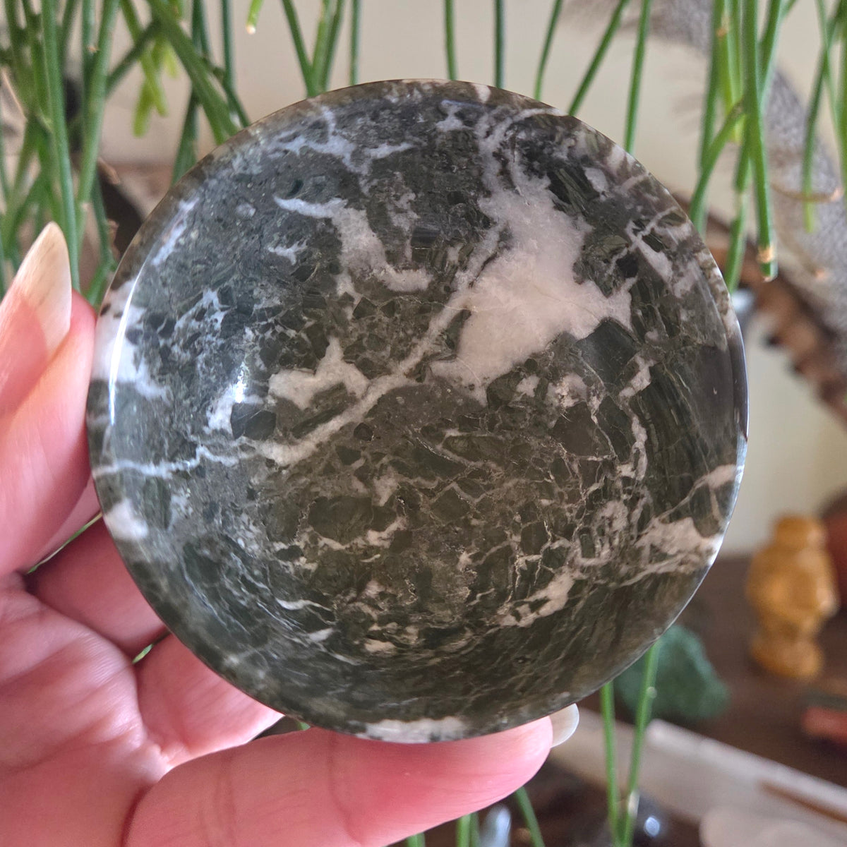 Marble-patterned stone held in a hand with a blurred background