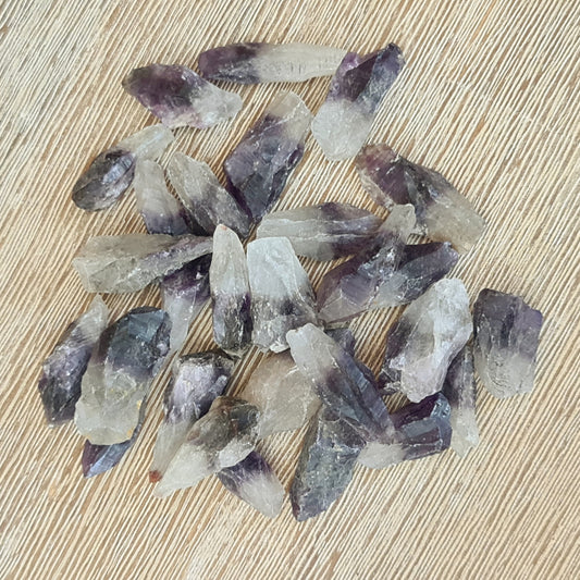 A collection of polished purple amethyst points on a wooden surface.