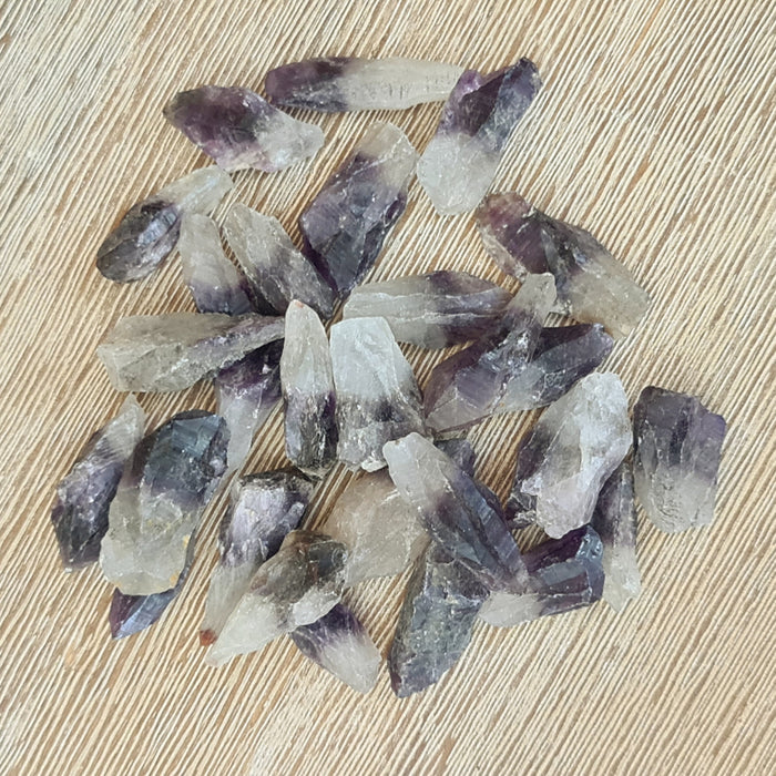 A collection of polished purple amethyst points on a wooden surface.
