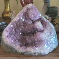 Amethyst crystal geode on a wooden surface with blurred background