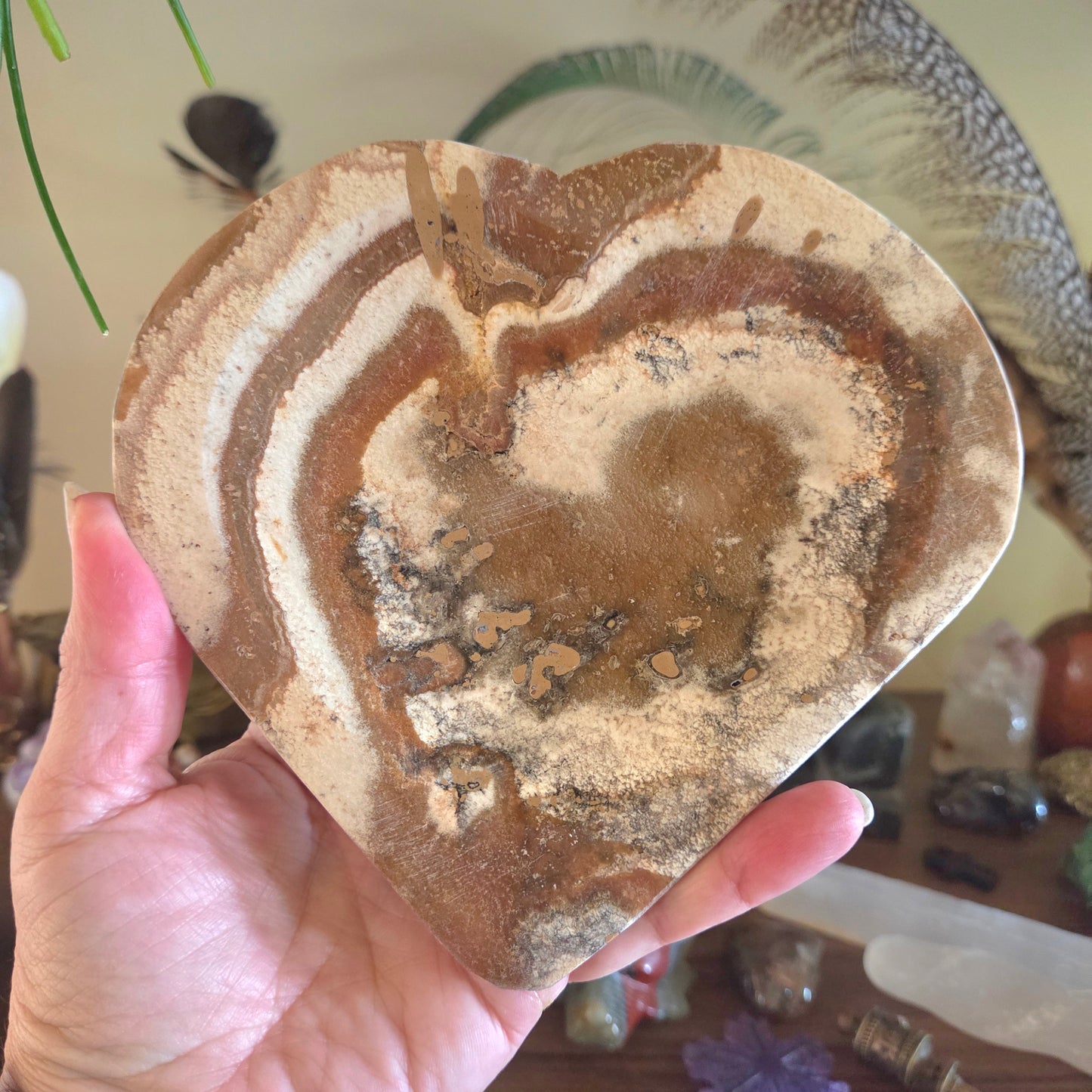 Heart-shaped geode held in a hand with a blurred indoor background