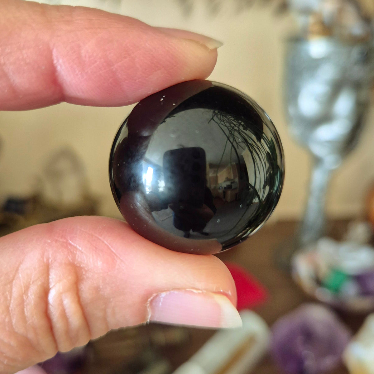 small black crystal sphere held in a hand