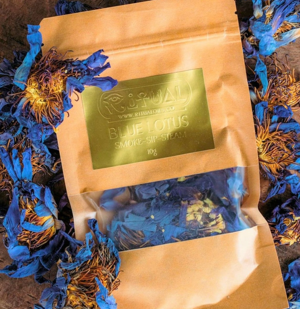 A package of Blue Lotus flowers with a few dried flowers scattered around, and a label on the package that reads 'Blue Lotus Smoke Blend' and indicates the weight of 10 grams.