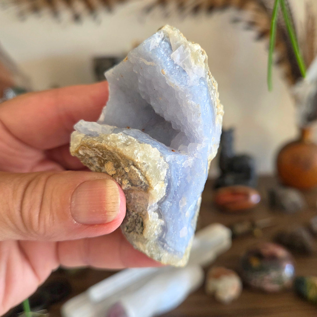 Hand holding a geode crystal with a blurred background