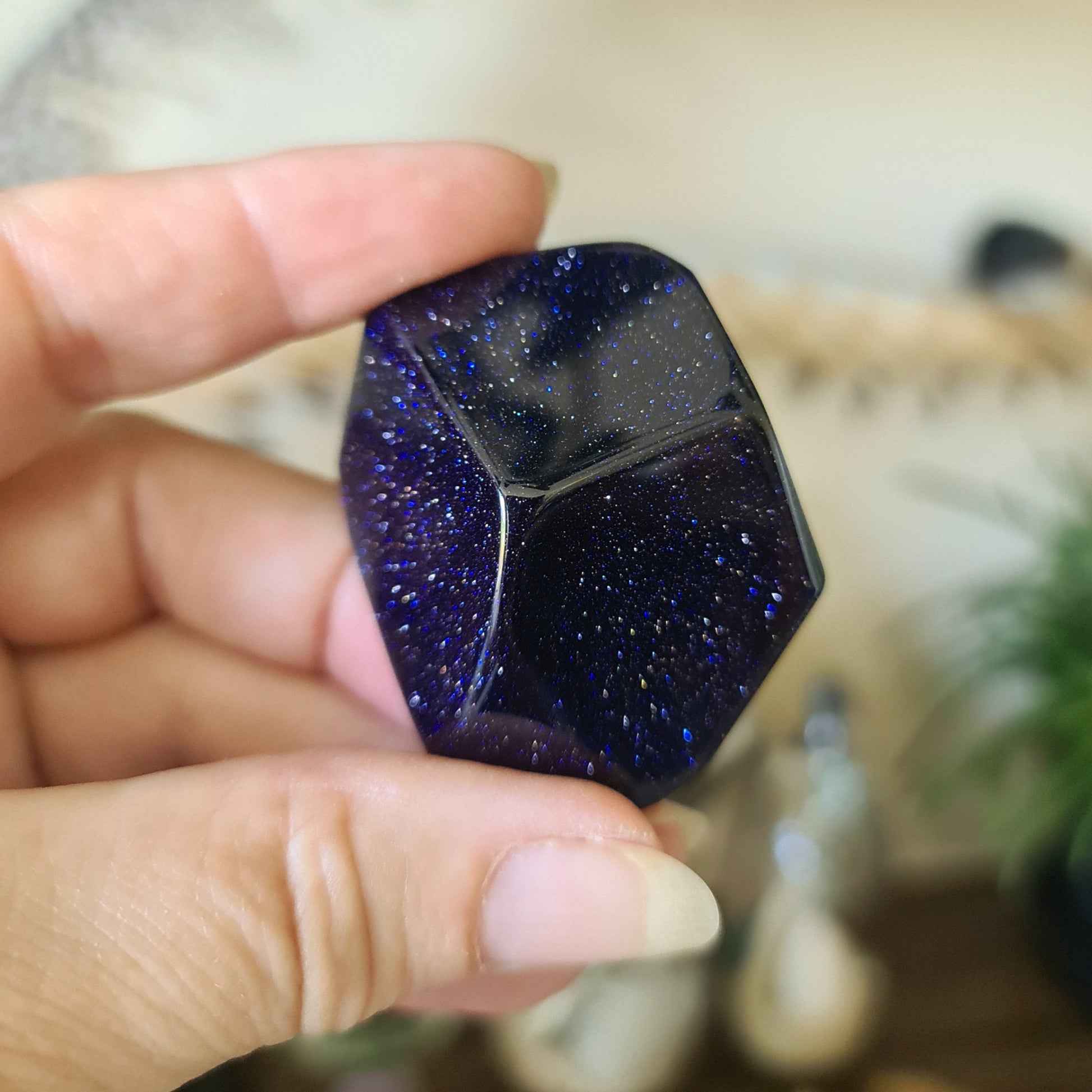 blue sparkly crystal held in a hand