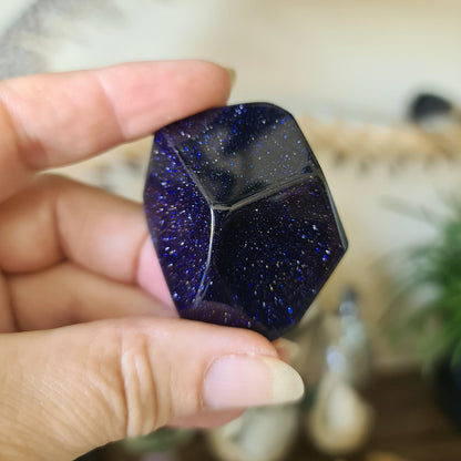 blue sparkly crystal held in a hand