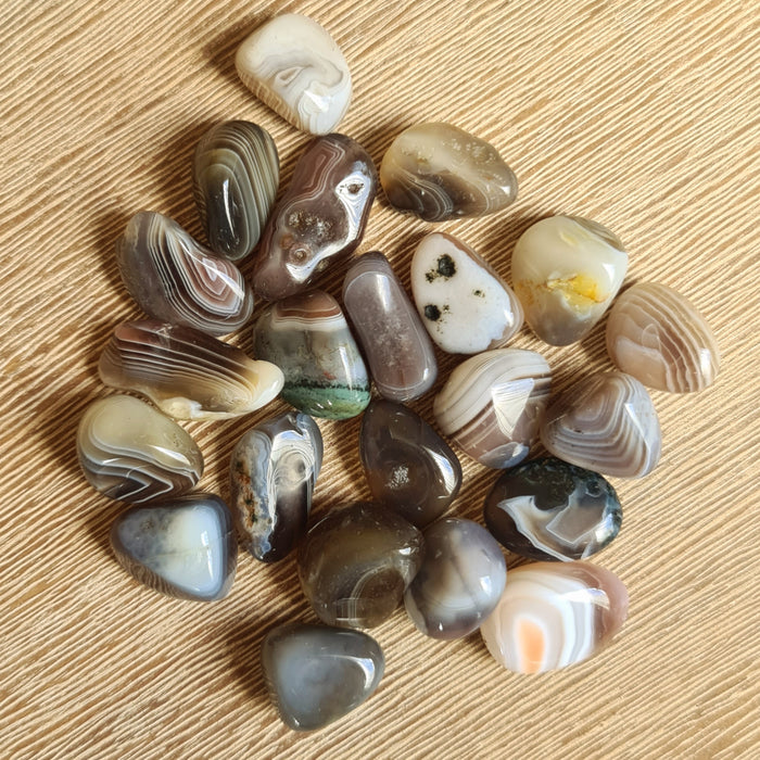 A collection of polished Botswana Agate tumble stones with varying colors and patterns.