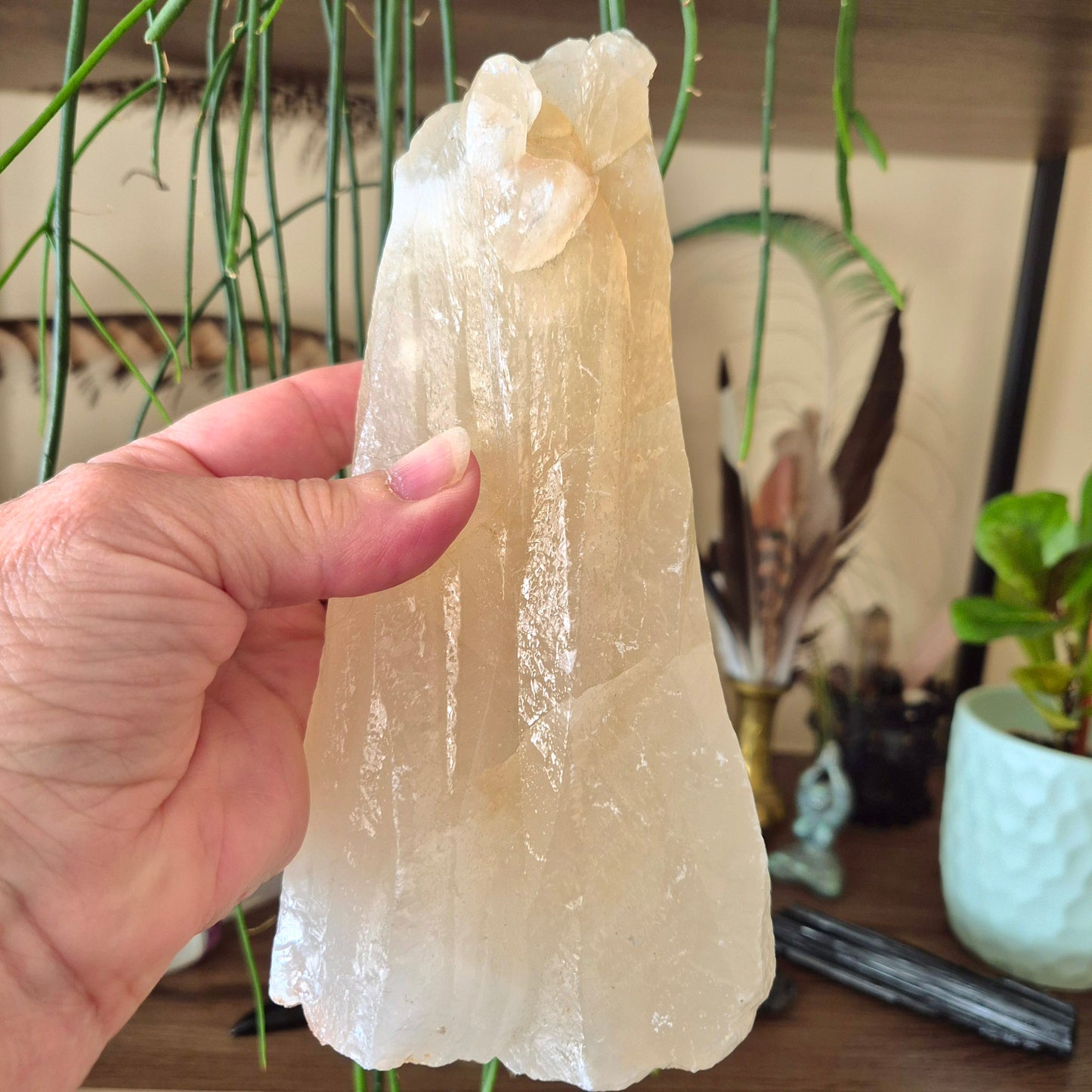 large raw calcite crystal held in a hand