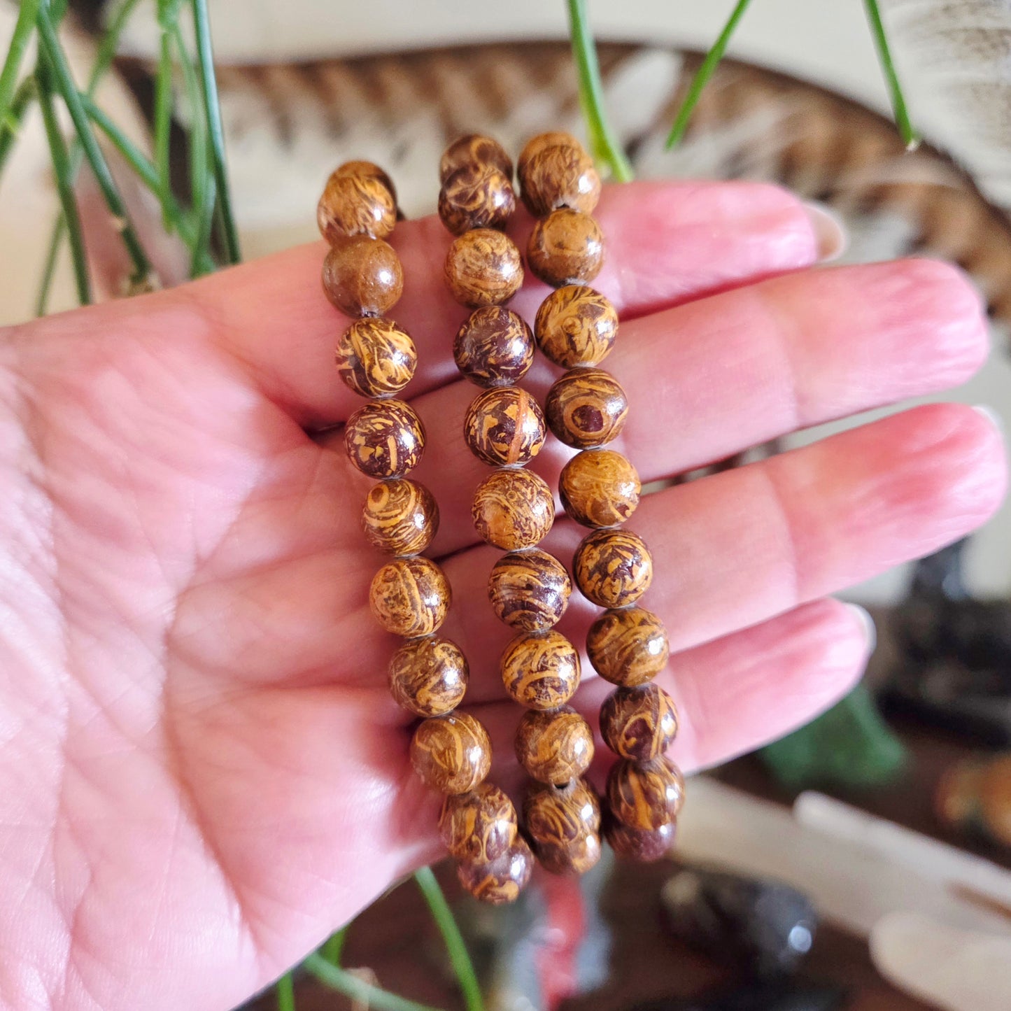 Wooden beaded bracelet held in a hand with a blurred background