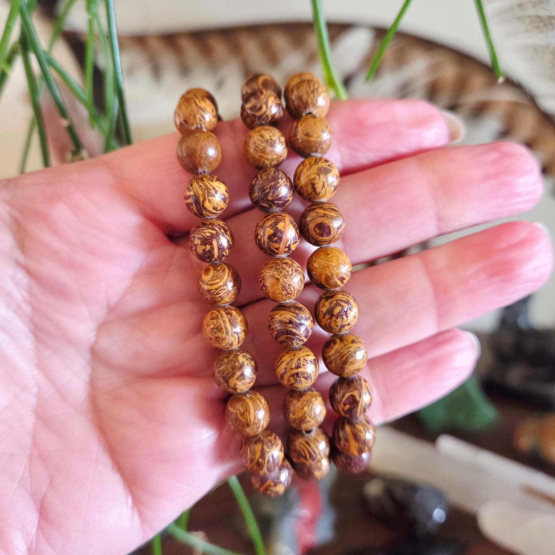 Wooden beaded bracelet held in a hand with a blurred background