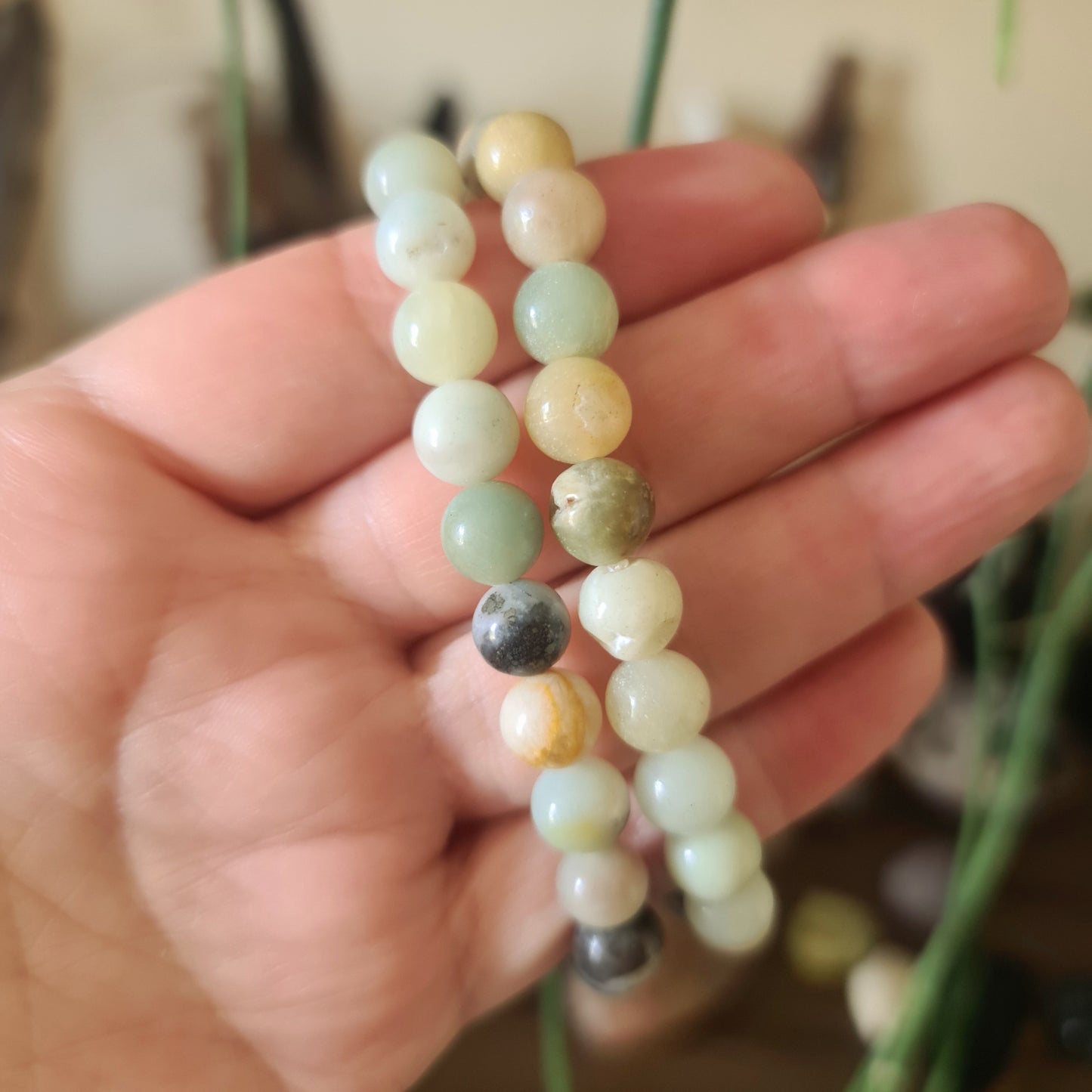 A multicolored beaded bracelet with a variety of colors, held in a person's hand.