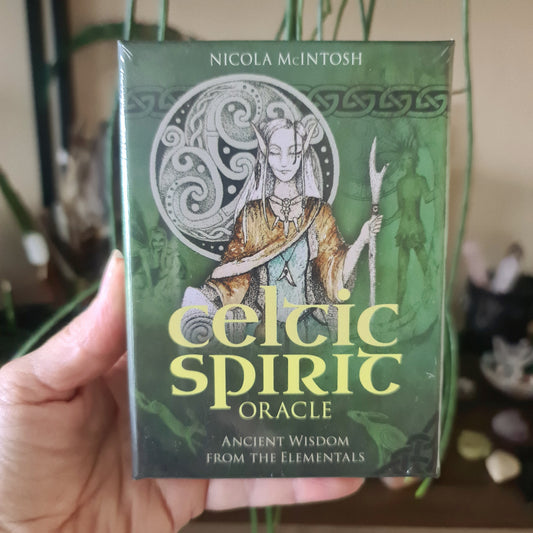 A boxed Celtic Spirit Oracle game with a illustration of a female figure wielding a staff, surrounded by elemental symbols.