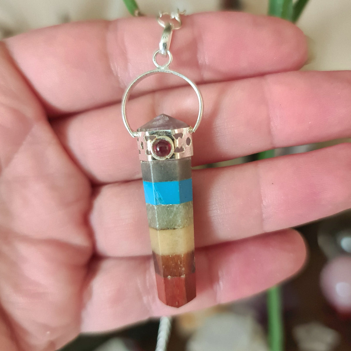 coloured pendulum held in the hand