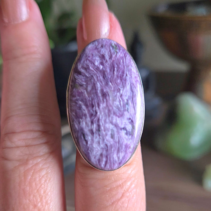 Purple stone ring on a finger with a blurred background