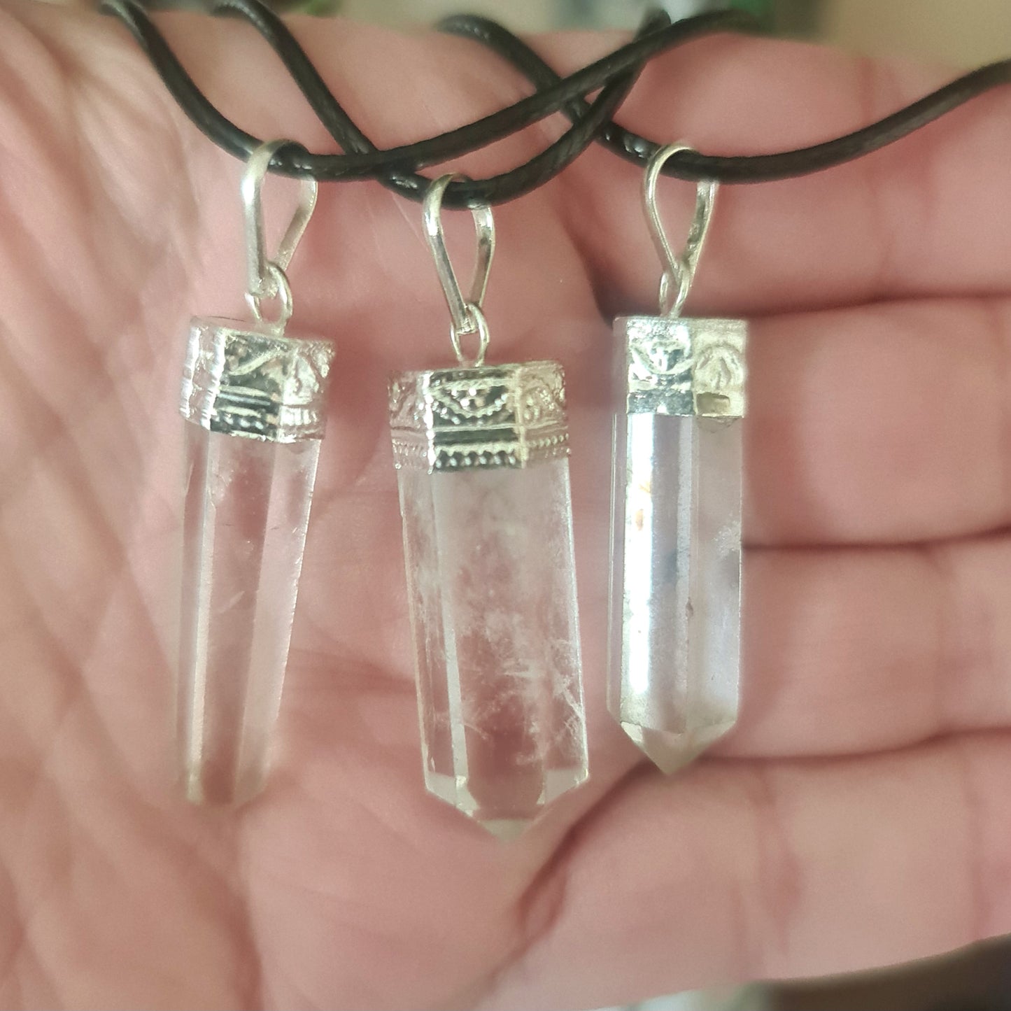 Two clear quartz crystal pieces attached to silver hooks, intended for use as a necklace.