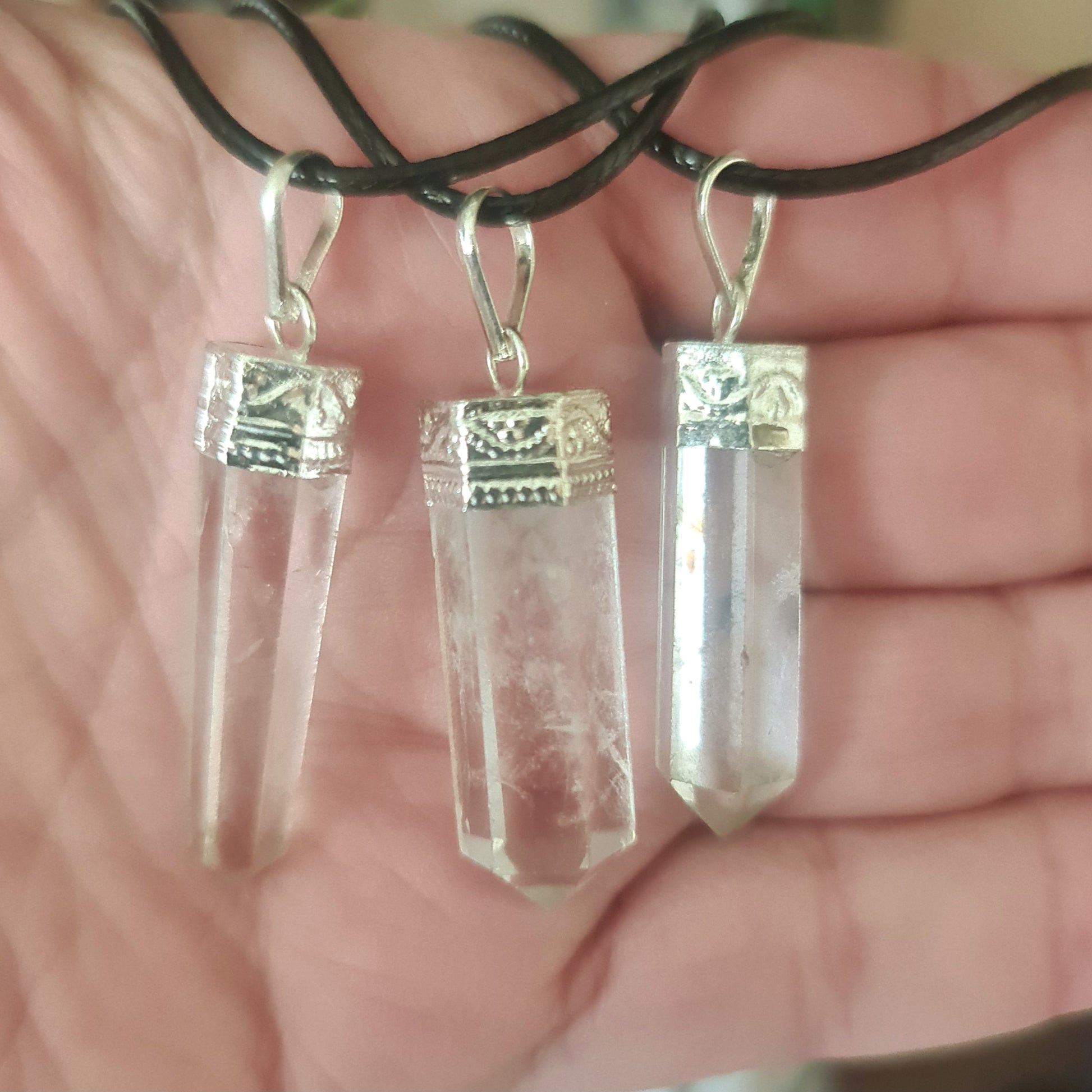 Two clear quartz crystal pieces attached to silver hooks, intended for use as a necklace.