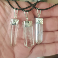 Two clear quartz crystal pieces attached to silver hooks, intended for use as a necklace.