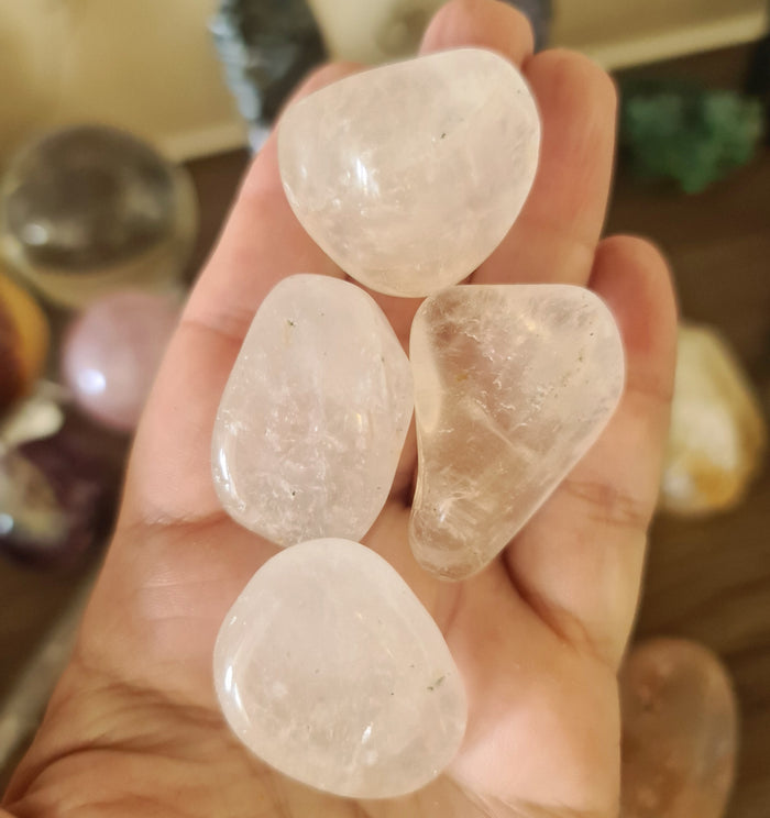A person holding several polished clear quartz crystals.