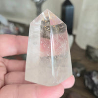 Clear crystal pyramid held in a hand with a blurred background