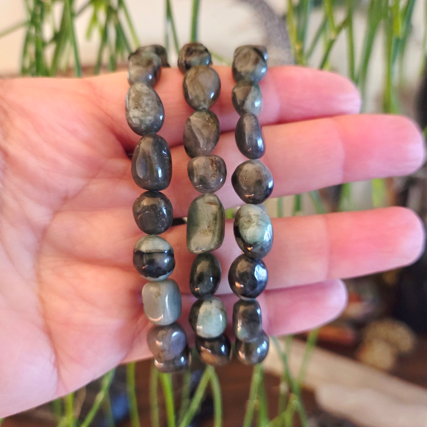 Three beaded bracelets on a hand with a blurred natural background