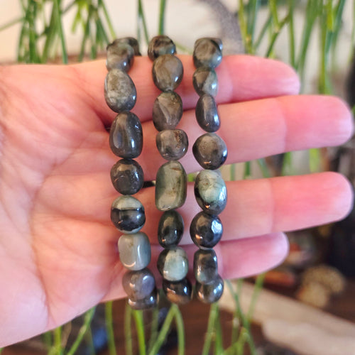 Three beaded bracelets on a hand with a blurred natural background