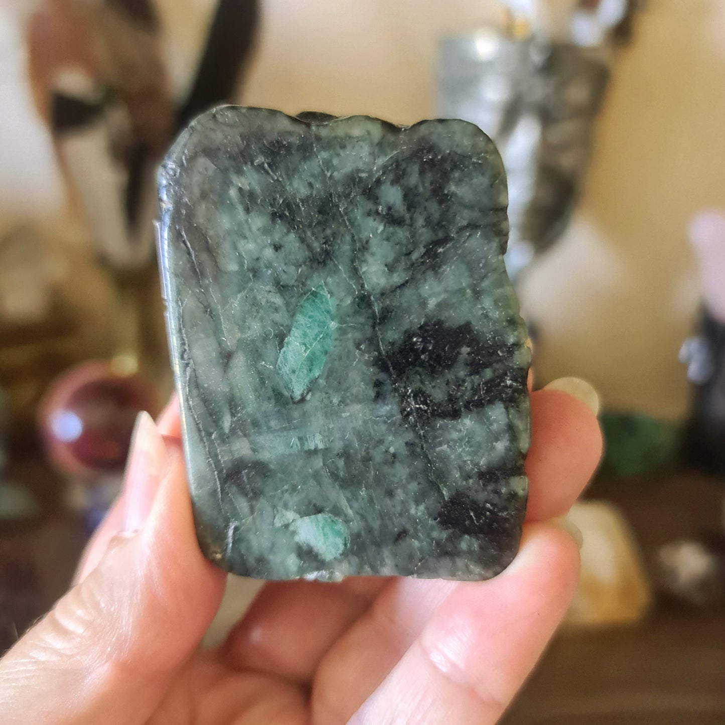 A person holding a large green emerald-colored rock, which is later identified as an emerald chunk.
