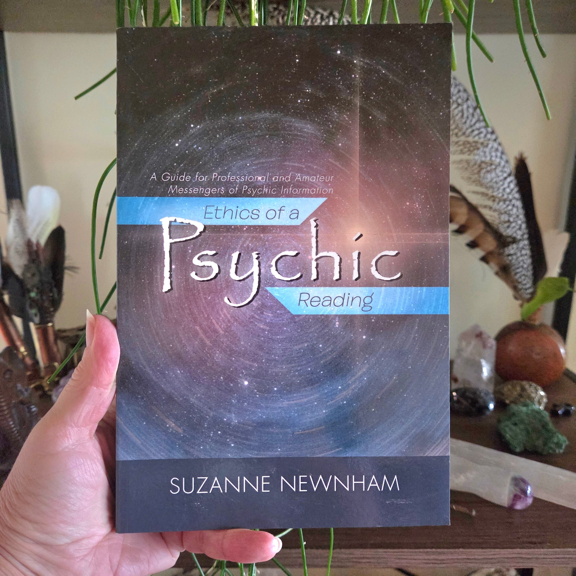 Book titled 'Ethics of a Psychic Reading' by Suzanne Newnham held in front of a mystical background.