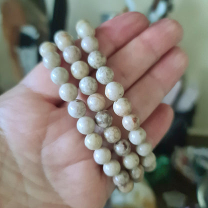 beige beaded bracelet held in a hand