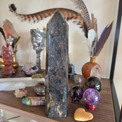 Decorative shelf with a tall crystal tower, colorful crystals, and various decorative items.