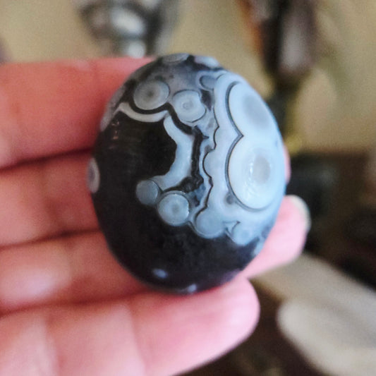 Black and white marbled stone held in a hand with a blurred background