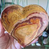 brown and green crystal onyx heart shaped plates held in a hand