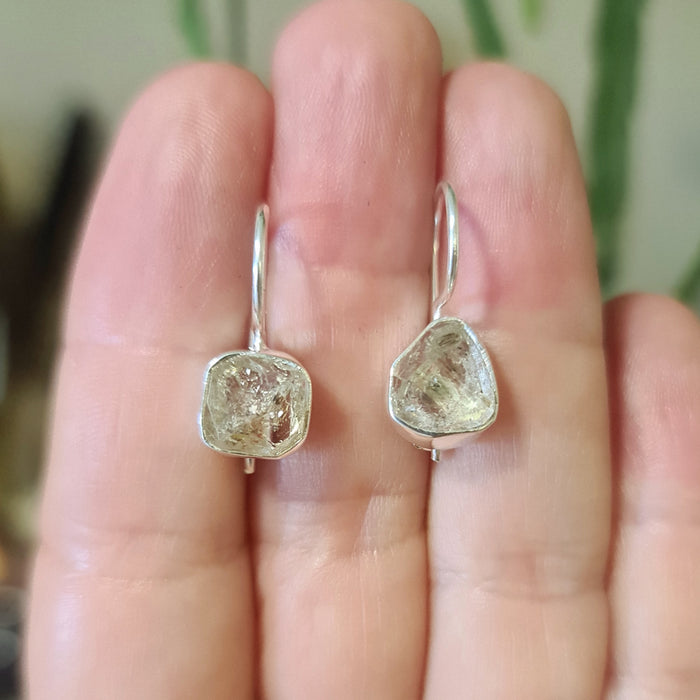 small herkimer diamond earrings on a hand