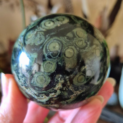 green tones crystal sphere held in a hand