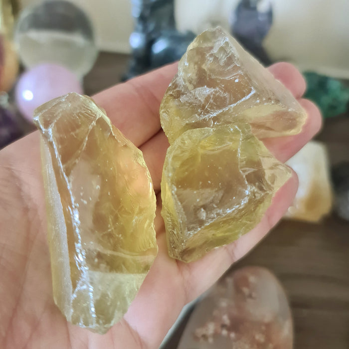 A person holding lemon quartz chunks with a blurred background.