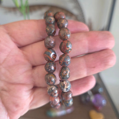Hand holding a beaded bracelet with a blurred background