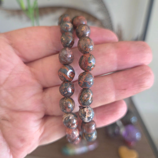 Hand holding a beaded bracelet with a blurred background