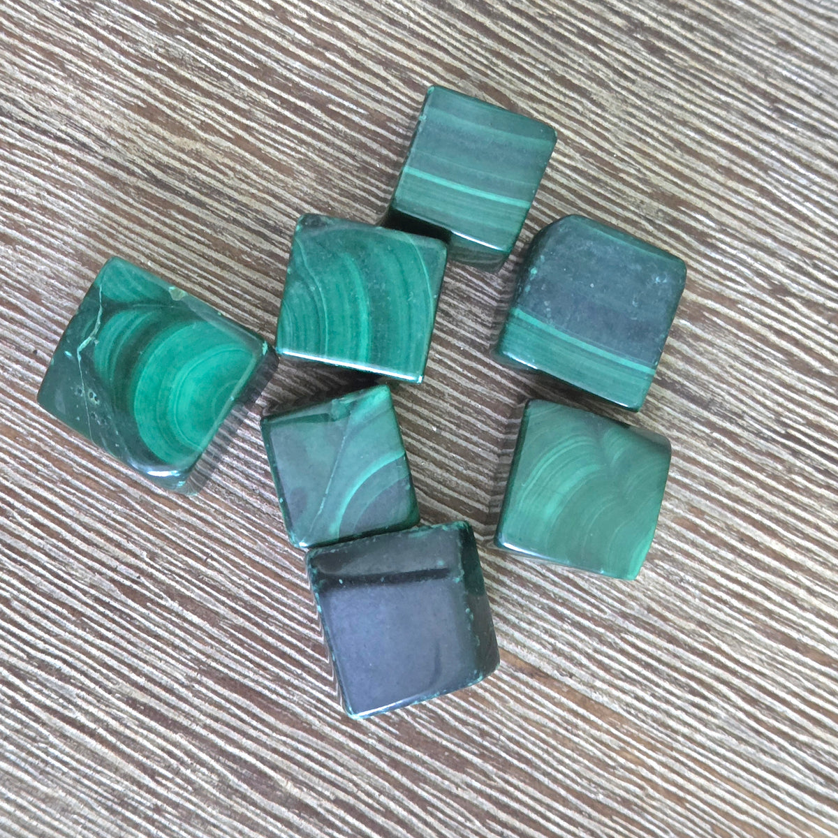 Green marbled cubes on a wooden surface