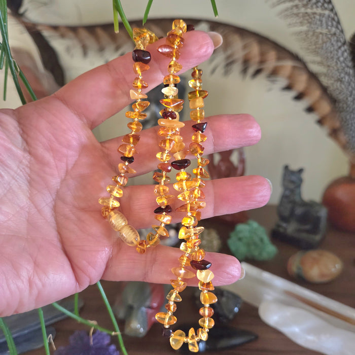 Hand holding a amber necklace with a blurred background