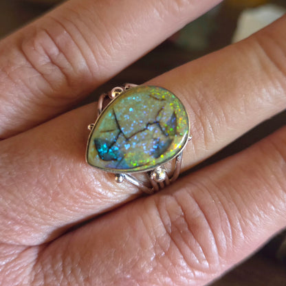 Ring with a large, colorful gemstone on a finger