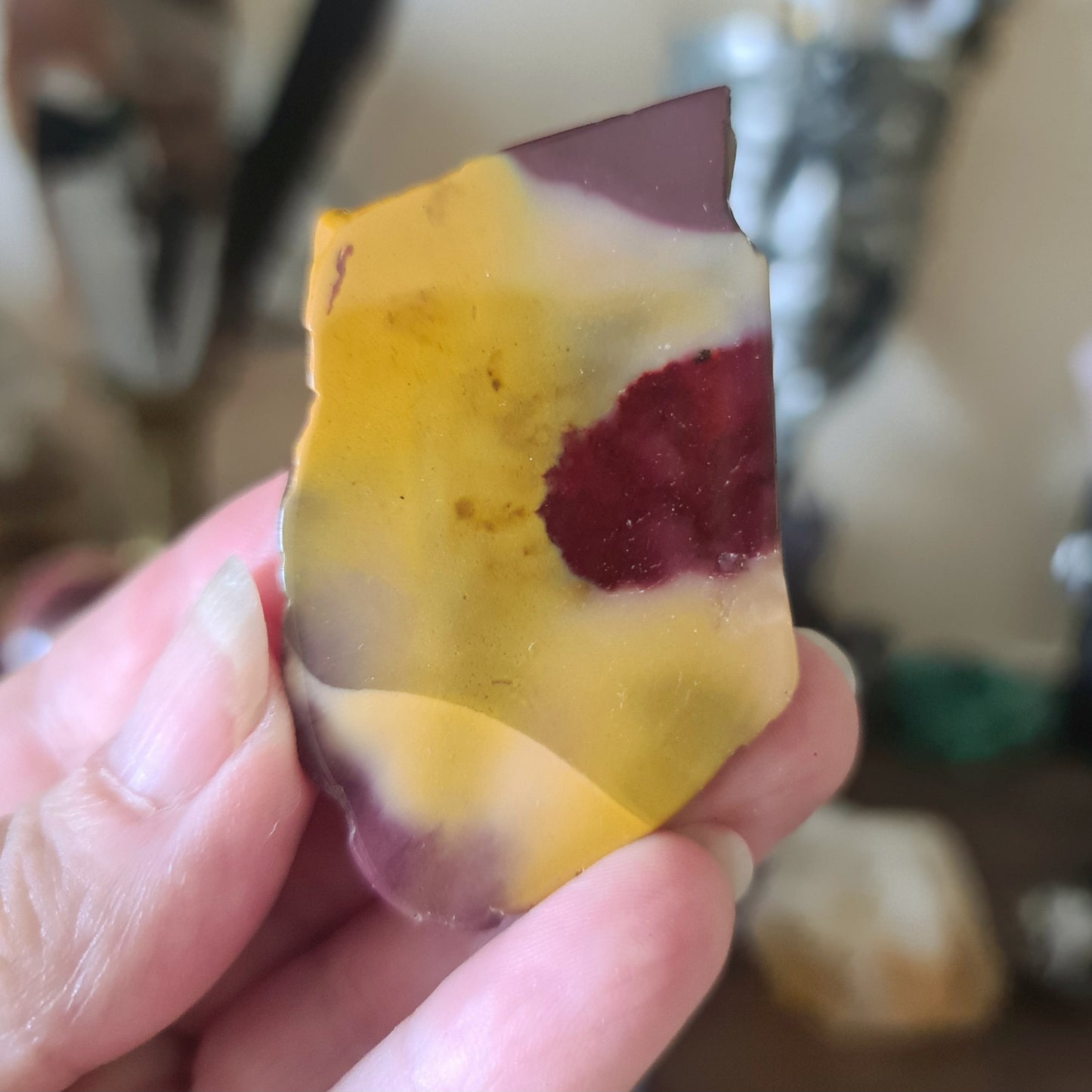yellow, red and white crystal tile held in a hand