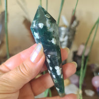 green and white sceptre held in a hand