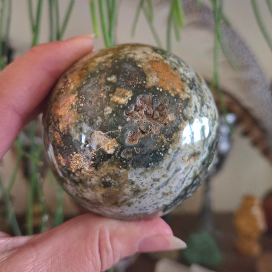 Person holding a textured stone ball with a blurred indoor background