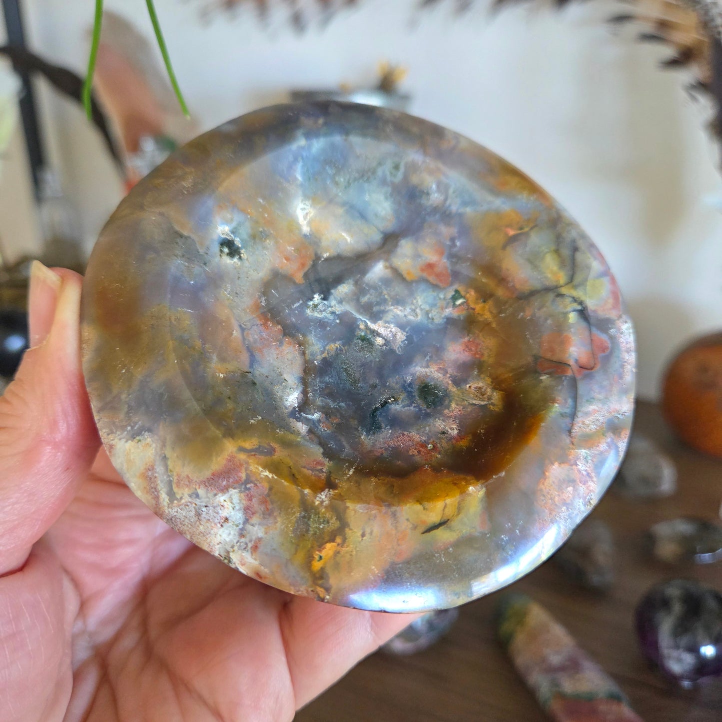 Hand holding a polished stone with a marbled pattern