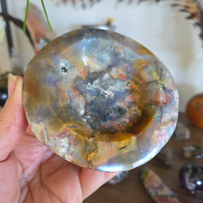 Hand holding a polished stone with a marbled pattern