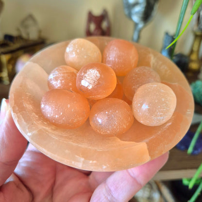 peach bowl with peach balls held in a hand