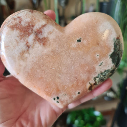 pink heart crystal held by a hand